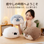 すやすや眠るアザラシの抱き枕ぬいぐるみを手に持ちリラックスする女性