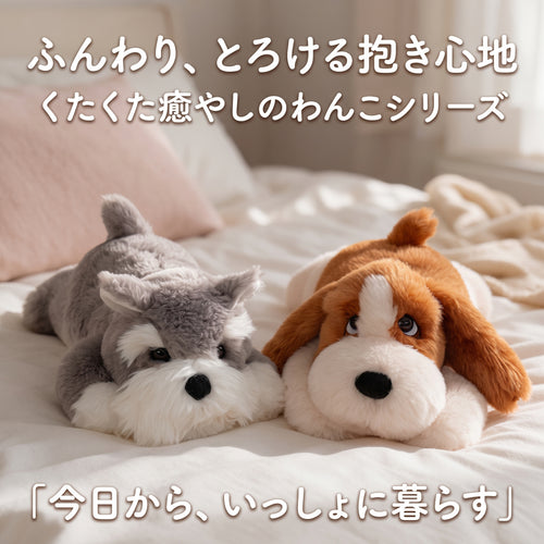 ベッドの上にくたくた並んで寝そべるシュナウザーとバセットハウンドのぬいぐるみ