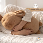 ベッドサイドでうさぎぬいぐるみを腕いっぱいに抱きしめるリラックスシーン