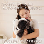 女性が胸元に抱きかかえるくたくた犬のぬいぐるみと穏やかなリラックスタイム