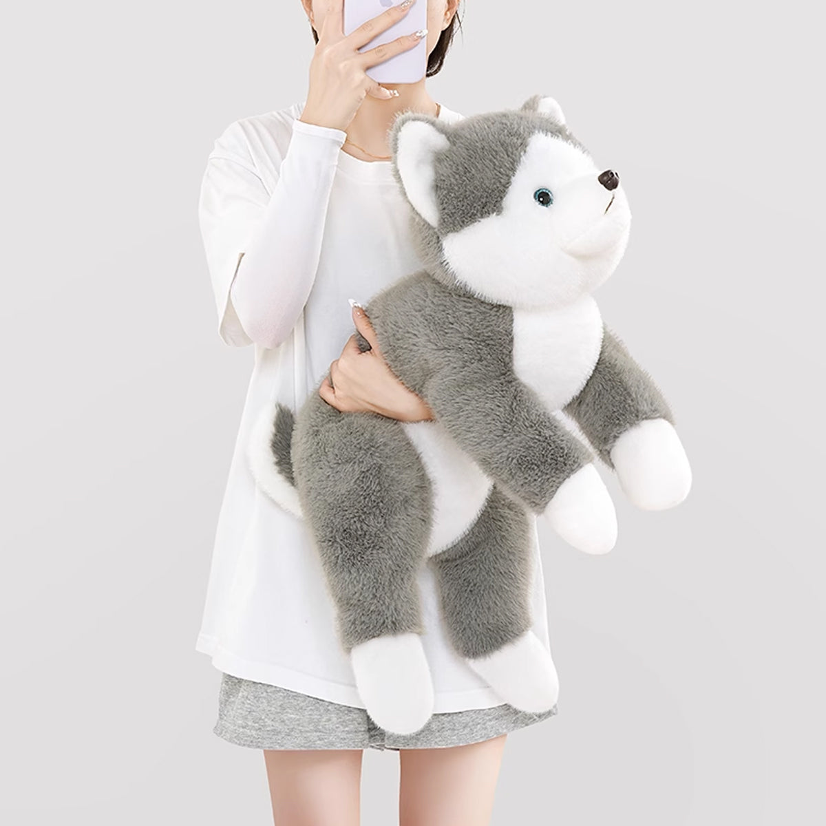 胸元にすっぽりと抱きかかえる大きいハスキーぬいぐるみのサイズ感