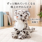 お部屋のマットの上でちょこんと座るユキヒョウぬいぐるみ。ずっと触れていたくなる極上のやわらかな肌触り