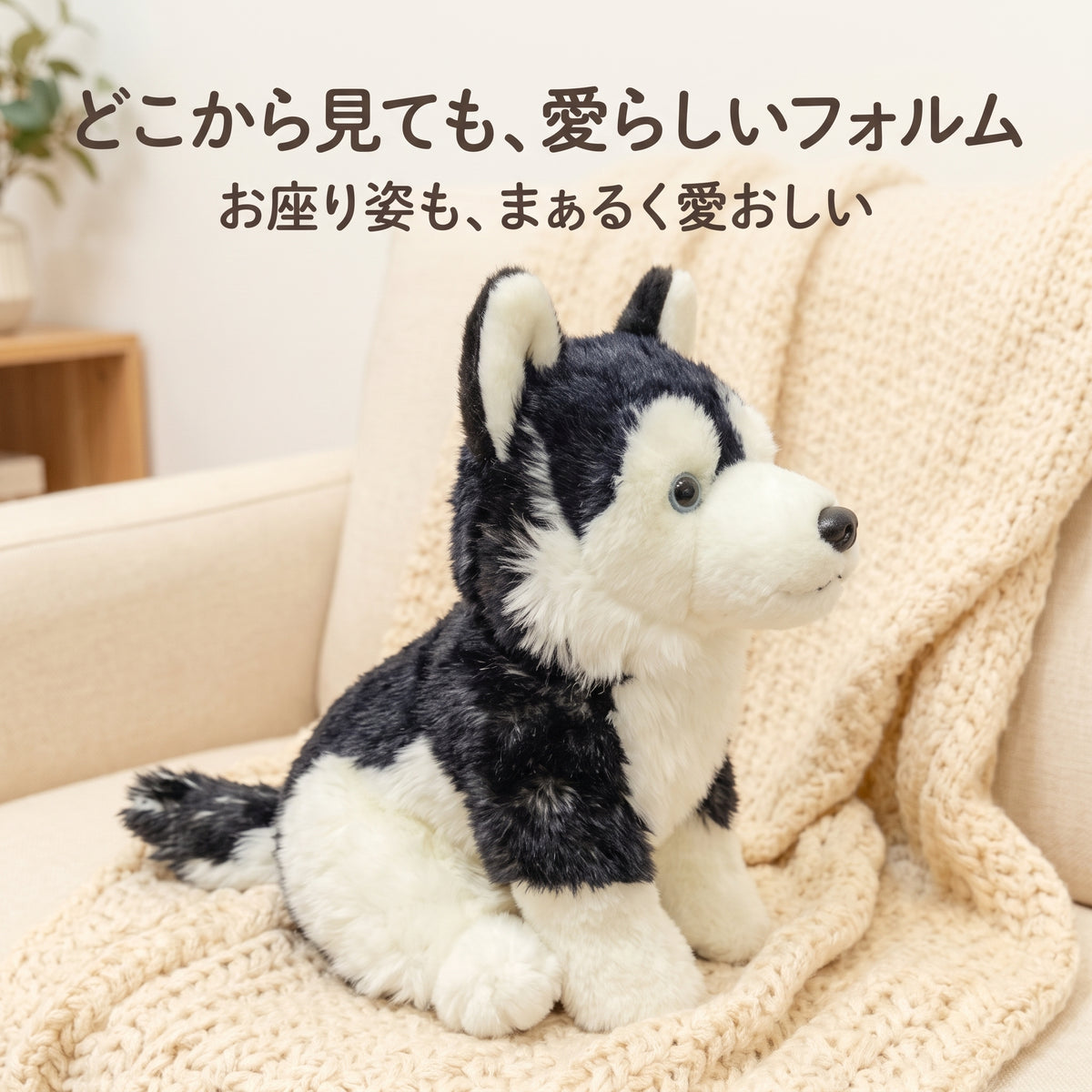 ソファに座るハスキーぬいぐるみのサイドビュー。ふっくらとした胸元と安定感のある愛らしいお座りポーズ