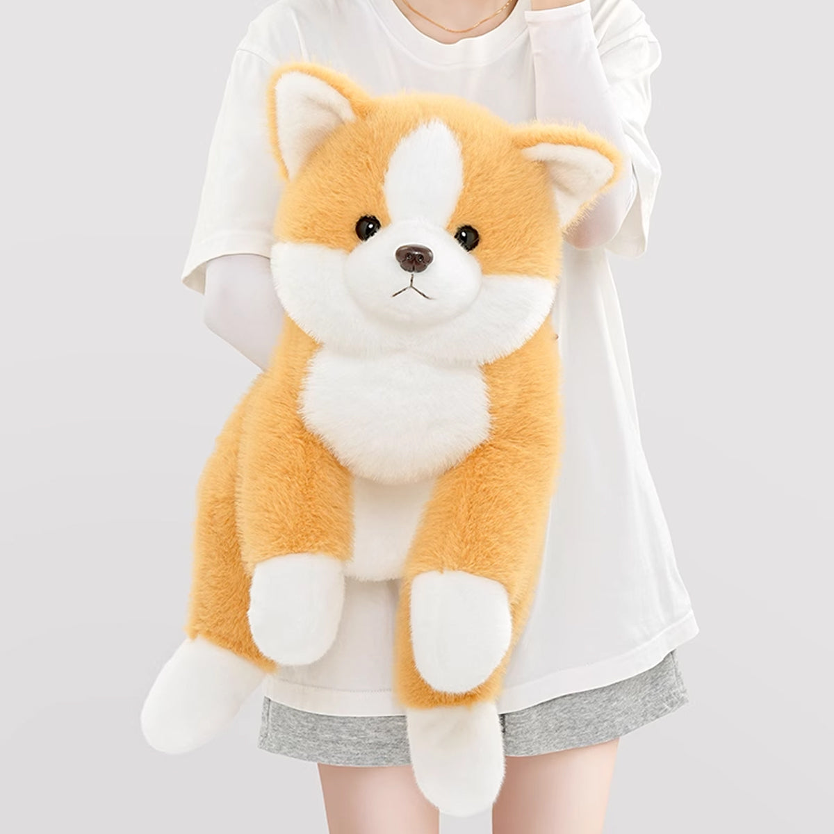 両手でしっかりと抱きしめた特大コーギーぬいぐるみのボリューム感
