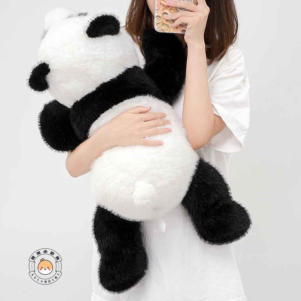 両手で抱きしめた特大パンダぬいぐるみのまあるい背中としっぽの後ろ姿