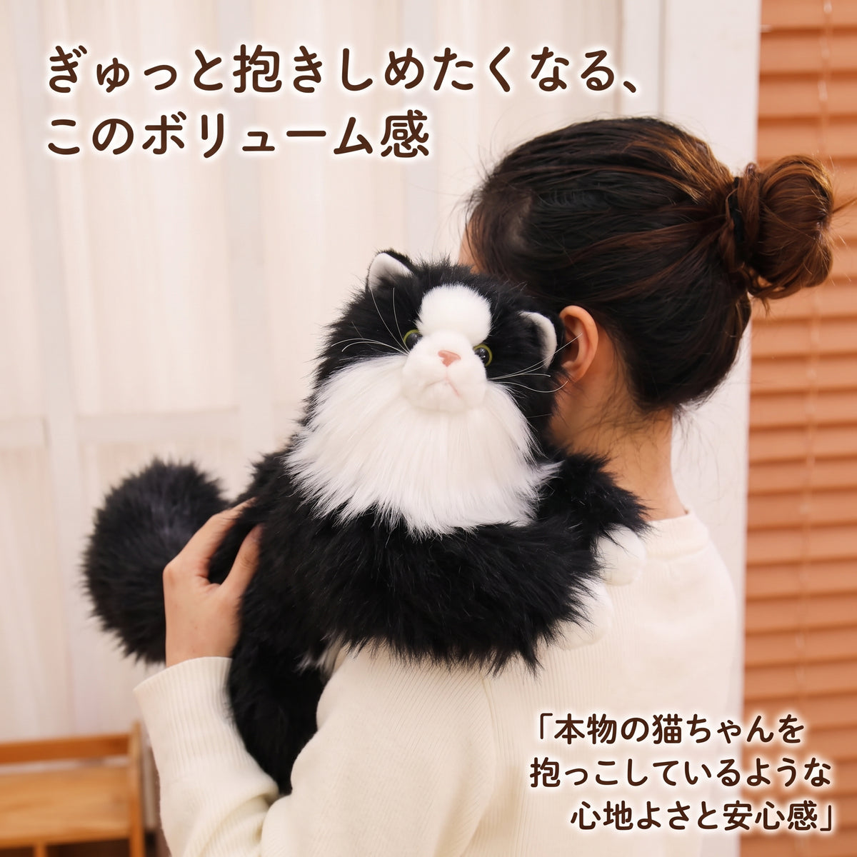 女性の肩に抱っこされてすっぽりと収まる特大・全長50cmのボリューミーなハチワレ猫ぬいぐるみ。本物の猫を抱いているような心地よさと安心感